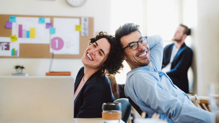 Um homem e uma mulher no trabalho lado a lado simulando o relacionamento interpessoal no trabalho