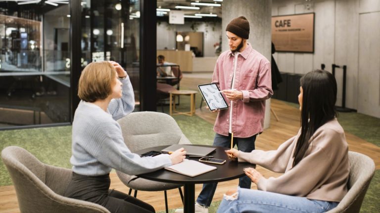 Foto de 3 pessoas em uma sala de coworking para representar a economia colaborativa