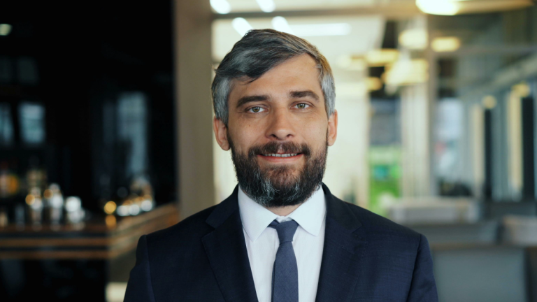 líder, em uma corporação, olhando para frente e sorrindo